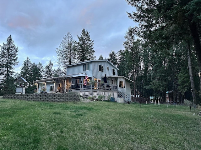 rear view of house featuring a lawn, a wooden deck, and cooling unit