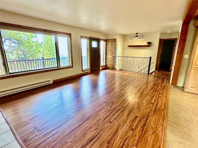 entrance foyer with light wood-style floors, baseboards, and a baseboard radiator