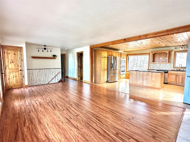 unfurnished living room featuring sink and light hardwood / wood-style floors