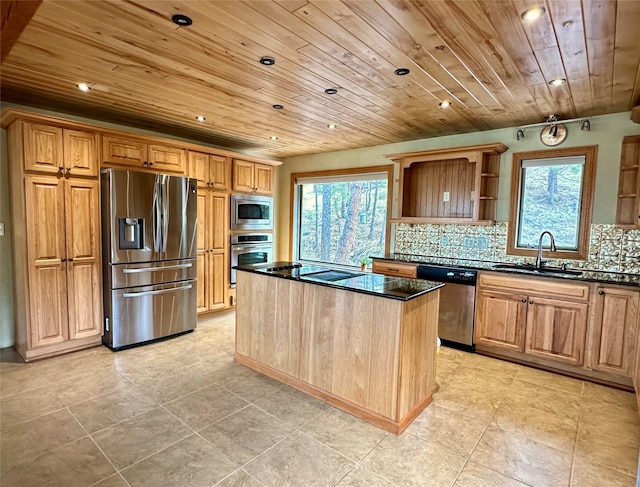 kitchen featuring backsplash, appliances with stainless steel finishes, sink, and a center island