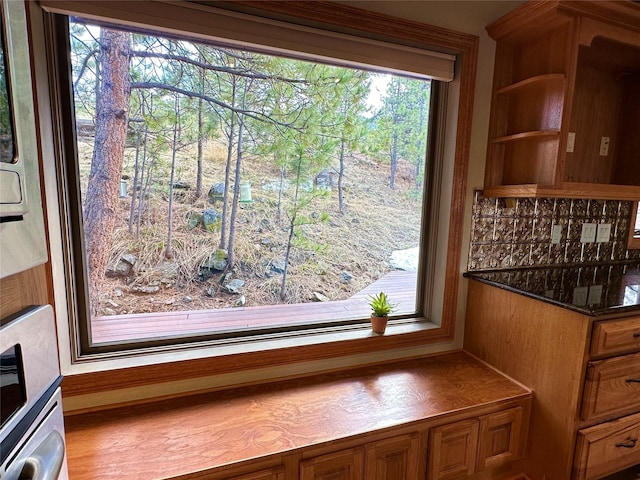 details featuring open shelves, brown cabinetry, backsplash, and built in shelves