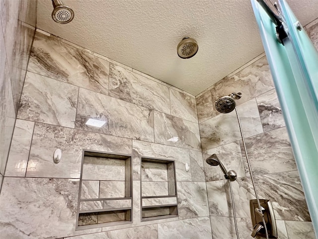 room details with a textured ceiling and tiled shower