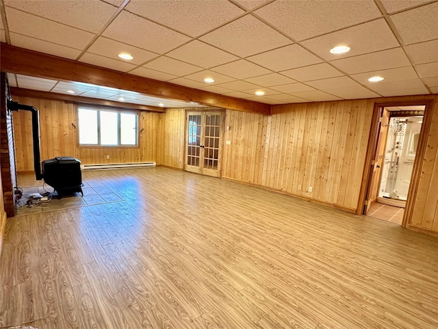 interior space featuring a wood stove, a paneled ceiling, and wood finished floors