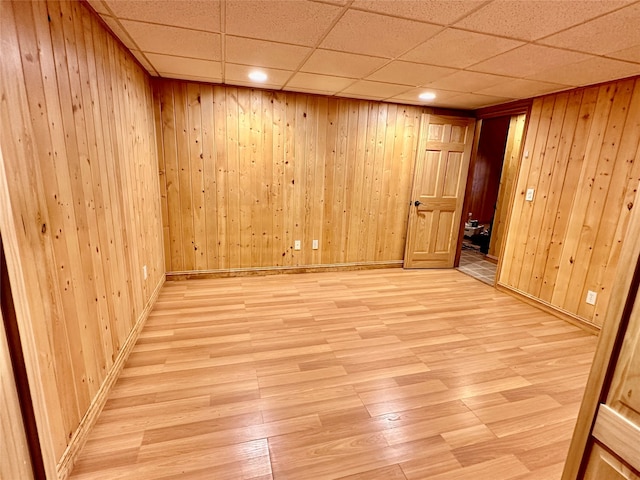 empty room featuring wooden walls and light hardwood / wood-style flooring