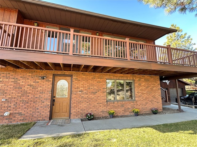 property entrance featuring brick siding and a balcony