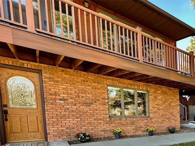 view of exterior entry with a balcony