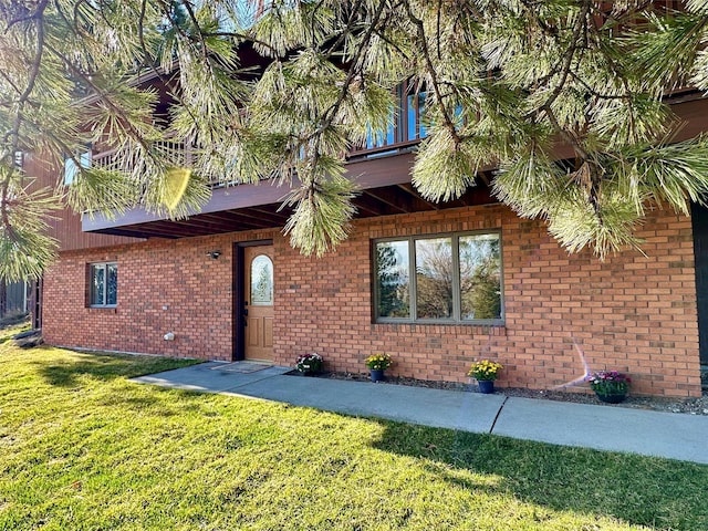 view of front facade featuring brick siding and a front yard
