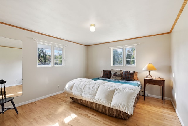 bedroom featuring light hardwood / wood-style floors, ornamental molding, and multiple windows