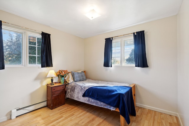 bedroom featuring light hardwood / wood-style flooring and a baseboard heating unit