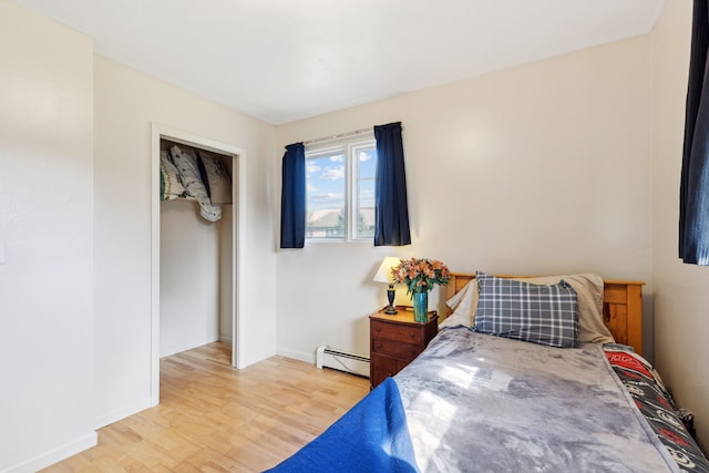 bedroom with light wood-type flooring and a baseboard radiator