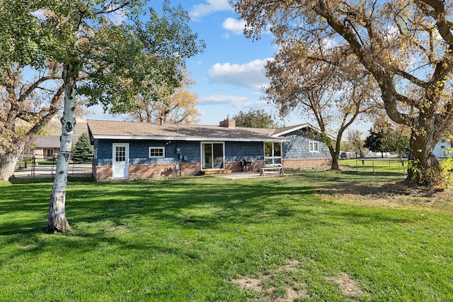 back of property with a patio area and a lawn