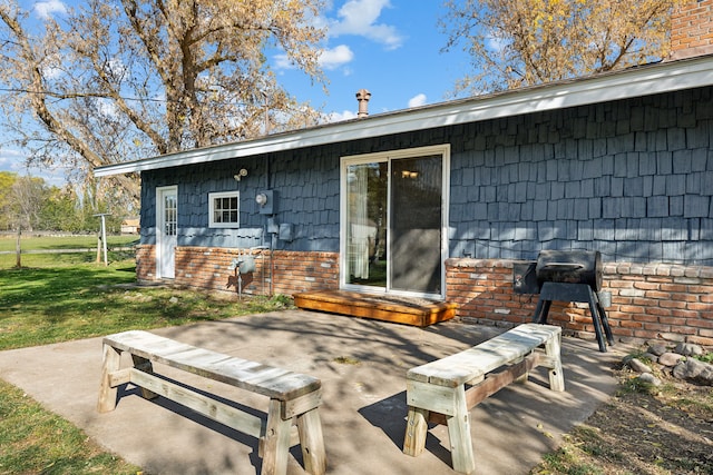 rear view of house with a patio area and a lawn