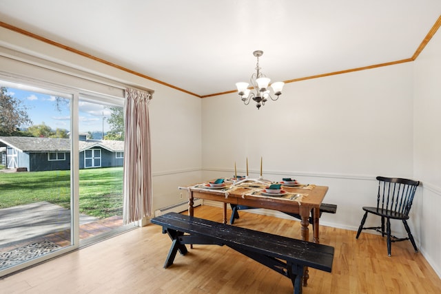 dining space with ornamental molding, light hardwood / wood-style floors, a notable chandelier, and a baseboard heating unit