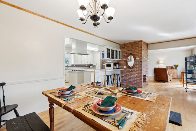 dining room with a notable chandelier, light hardwood / wood-style floors, and crown molding