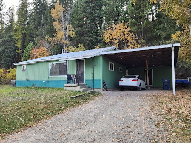33762 US Highway 2, Libby, MT 59923 - view of front of house with dirt driveway, a carport, a metal roof, and a view of trees
