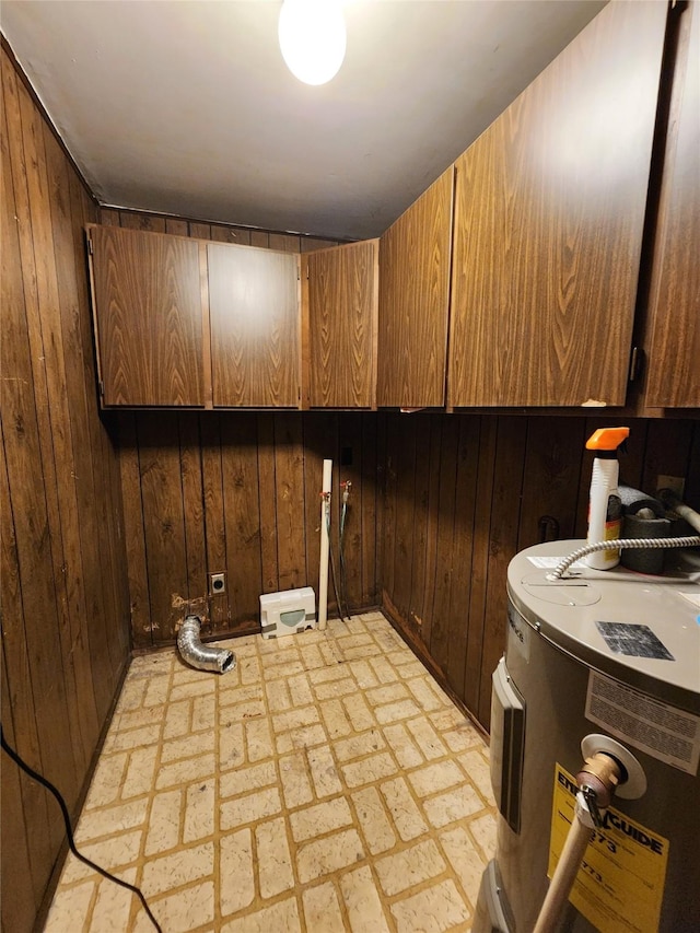 33762 US Highway 2, Libby, MT 59923 - laundry area featuring cabinet space, water heater, wooden walls, and brick patterned flooring