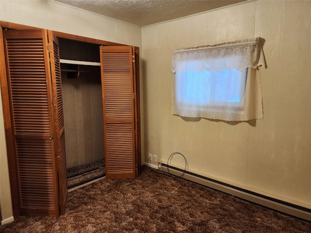 33762 US Highway 2, Libby, MT 59923 - unfurnished bedroom featuring a baseboard radiator, carpet flooring, a closet, and a textured ceiling