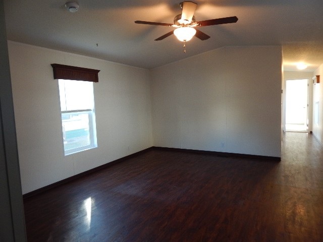 unfurnished room featuring ceiling fan, lofted ceiling, and dark hardwood / wood-style floors