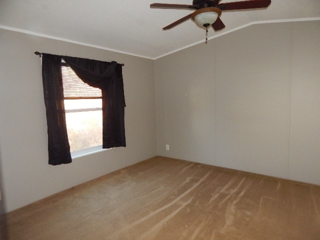 empty room with ornamental molding, ceiling fan, carpet flooring, and vaulted ceiling