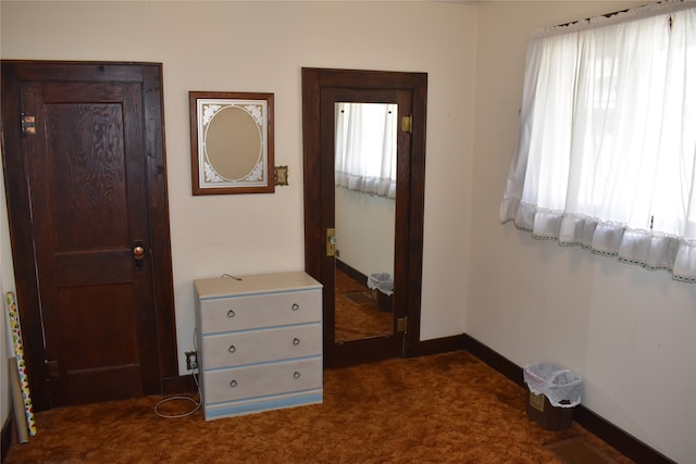 hallway featuring dark colored carpet