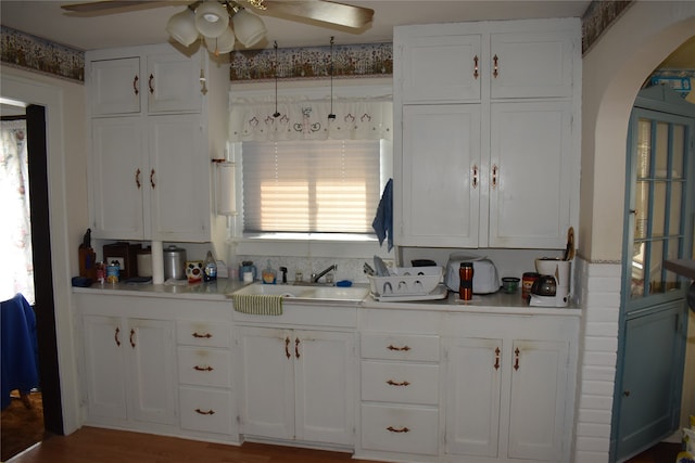 kitchen with white cabinetry, sink, wood-type flooring, and ceiling fan