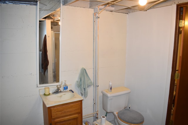 bathroom featuring vanity, toilet, and a shower with door