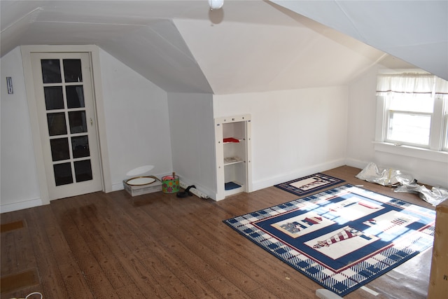 bonus room with dark wood-type flooring and vaulted ceiling