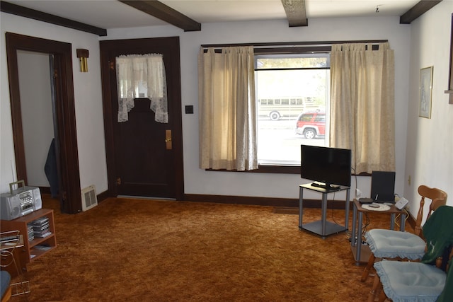 foyer entrance with beamed ceiling and carpet floors