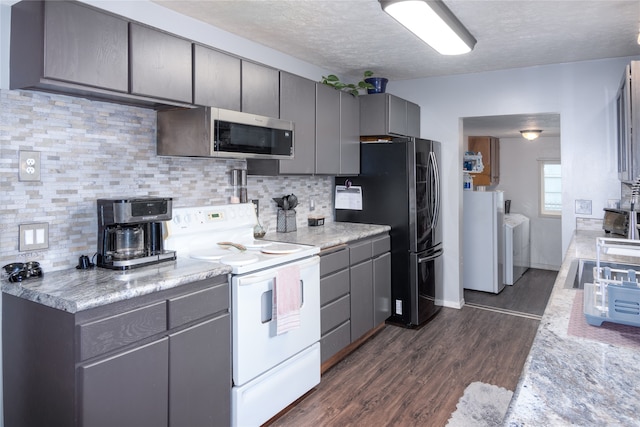 kitchen featuring appliances with stainless steel finishes, backsplash, a textured ceiling, washing machine and clothes dryer, and dark wood-type flooring