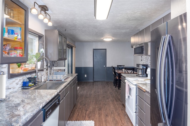 kitchen with tasteful backsplash, appliances with stainless steel finishes, sink, and dark hardwood / wood-style floors