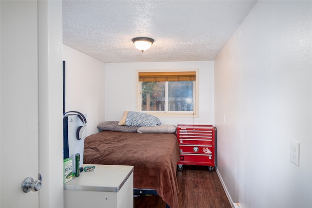 bedroom with a textured ceiling and dark hardwood / wood-style floors