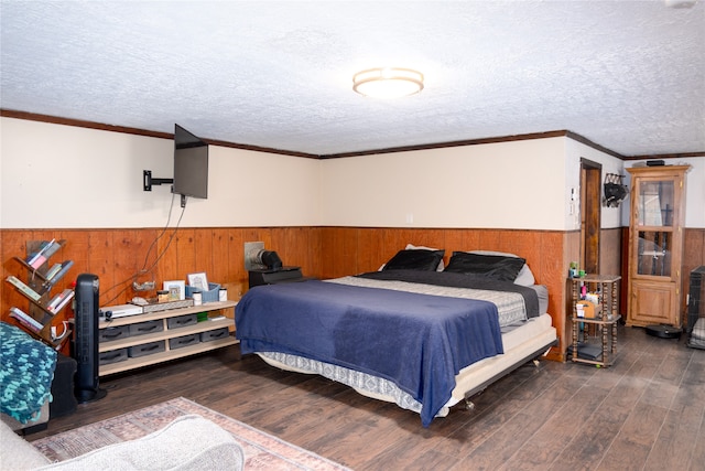 bedroom featuring dark wood-type flooring, crown molding, a textured ceiling, and wood walls