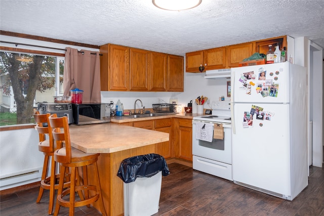 kitchen featuring a textured ceiling, dark hardwood / wood-style floors, sink, and white appliances