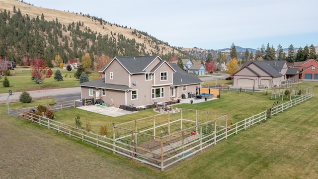 10636 Nez Perce Loop, Lolo, MT 59847 - back of house with a patio, a mountain view, and a fenced backyard