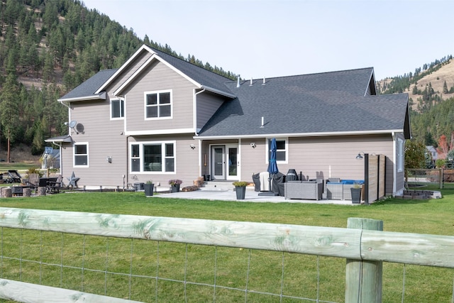 10636 Nez Perce Loop, Lolo, MT 59847 - rear view of house featuring an outdoor living space, a patio, a yard, and roof with shingles