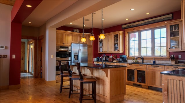 4025 Sunset Ridge Dr, Helena, MT 59602 - kitchen with light wood-style flooring, a sink, appliances with stainless steel finishes, a kitchen bar, and recessed lighting