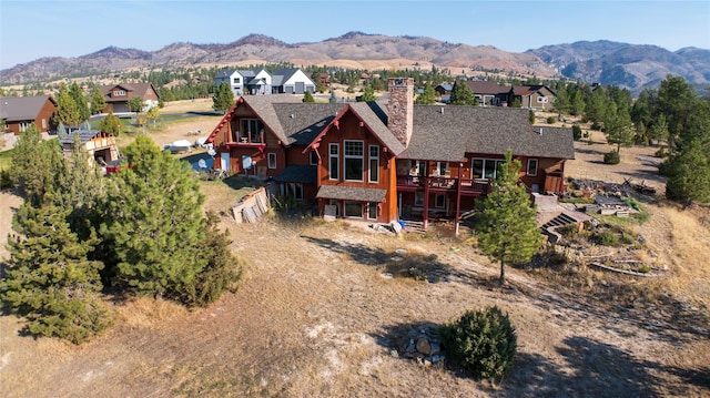 4025 Sunset Ridge Dr, Helena, MT 59602 - rear view of house with a residential view, roof with shingles, a deck with mountain view, and a chimney