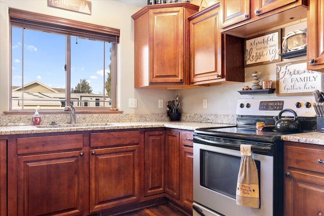 kitchen with light stone counters, stainless steel range with electric stovetop, sink, and dark hardwood / wood-style flooring