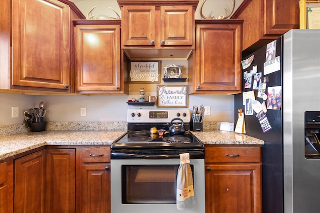 kitchen with appliances with stainless steel finishes and light stone countertops