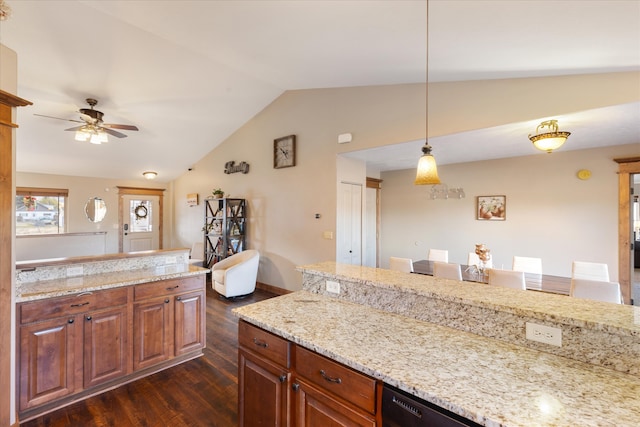 kitchen featuring ceiling fan, vaulted ceiling, dark hardwood / wood-style floors, pendant lighting, and light stone counters