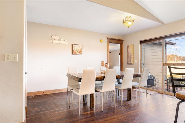 dining space with vaulted ceiling and dark hardwood / wood-style flooring