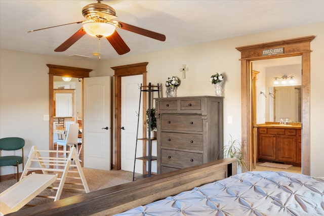 bedroom with sink, ensuite bathroom, light colored carpet, and ceiling fan