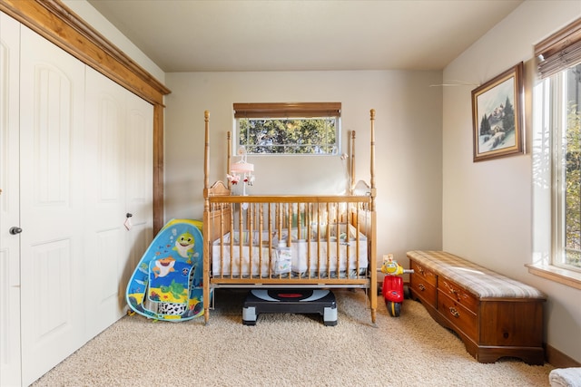 bedroom featuring a closet, a nursery area, multiple windows, and carpet floors