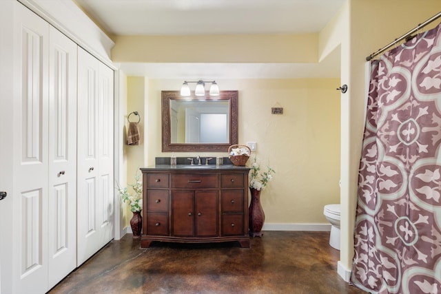 bathroom with toilet, concrete flooring, and vanity