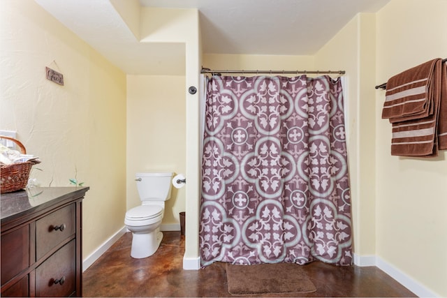 bathroom featuring concrete floors, vanity, and toilet