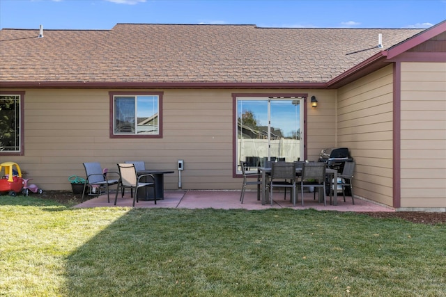 rear view of house with a patio and a lawn