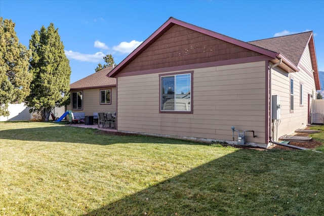 view of side of home with a patio area and a yard