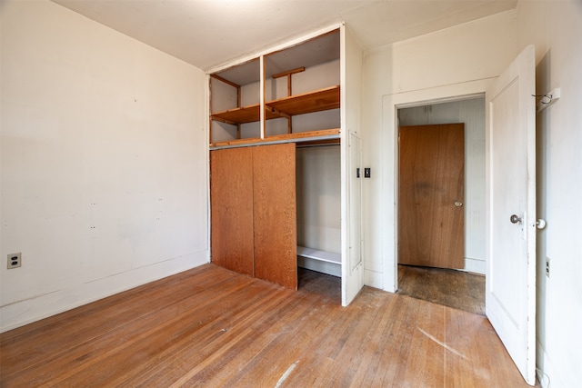 unfurnished bedroom featuring a closet and hardwood / wood-style floors