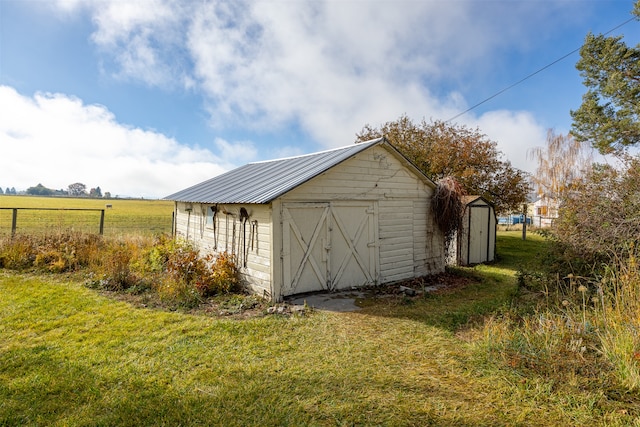 view of outdoor structure featuring a lawn and a rural view