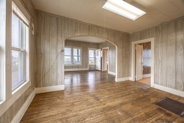 spare room featuring hardwood / wood-style flooring and wooden walls